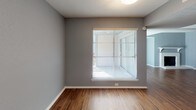 This single-floor, 2-bedroom, 2-bathroom residence offers a thoughtfully designed layout that balances comfort and functionality. Throughout the home, warm wood-style flooring creates a cohesive and inviting aesthetic, complemented by cool gray-toned walls that lend a modern, neutral palette to every room.

The kitchen is efficiently arranged with white cabinetry, granite-style countertops, and stainless steel appliances including a range and microwave. A pantry closet provides additional storage, and the layout maximizes workspace for everyday cooking. 

The living area features an exposed beam detail and a fireplace, giving the space added character. Natural light filters in through windows fitted with horizontal blinds, enhancing the open feel of the room.

Both bedrooms are generously sized, each equipped with ceiling fans with light fixtures and windows that allow natural light to flow in. The rooms offer ample space for furnishing and personal use.

Each bathroom is well-appointed with granite-topped vanities, white cabinetry, and full tub-shower combinations with clean white tile surrounds. Brushed nickel fixtures and framed mirrors complete the polished look. One bathroom features additional overhead cabinet storage for added convenience.

Overall, this residence delivers a clean, contemporary living environment with practical features and consistent finishes throughout.