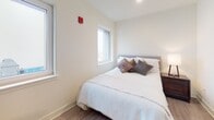 Located at 901 N Market St in the heart of Wilmington, Delaware, this well-appointed single-floor unit offers a thoughtfully designed layout with modern finishes throughout. The living area is warm and inviting, featuring light wood-style flooring, crisp white walls, and accents of color provided by vibrant wall art and richly upholstered seating. A dedicated closet with louvered doors adds practical storage directly off the living space.

The kitchen is a standout feature, outfitted with two-tone cabinetry — sleek white upper cabinets illuminated by under-cabinet lighting paired with dark wood-finish lower cabinets — along with stainless steel appliances including a full-size refrigerator, dishwasher, and range. Light wood flooring continues seamlessly throughout, tying the spaces together.

The bedroom is bright and serene, benefiting from multiple windows that invite natural light and offer views of the surrounding cityscape. A spacious closet provides generous storage.

The full bathroom features an elongated double-sink vanity with white countertops, ample cabinetry, tile flooring, and a shower with curtain enclosure. A dedicated utility room houses a stacked Whirlpool washer and dryer alongside a full-size water heater, providing convenient in-unit laundry. The unit also includes an accessible electrical panel, reflecting a complete and functional residential setup.