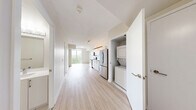 Located at 763 Woodbine Ave in Toronto's East End, this one-bedroom, one-bathroom unit offers a well-designed layout with a clean, contemporary aesthetic throughout. Light-toned hardwood flooring runs continuously across the main living areas, enhancing the sense of openness and warmth.

The kitchen is efficiently arranged with crisp white cabinetry extending to the ceiling for ample storage, a light tile backsplash, white countertops, and a full suite of stainless steel appliances including a range, over-the-range microwave, refrigerator, and dishwasher.

The living area flows directly from the kitchen, creating a cohesive open-concept space. The bedroom is a well-proportioned retreat featuring a sliding-door closet and large floor-to-ceiling windows with direct access to a private balcony, where views of the surrounding neighbourhood and greenery can be enjoyed. Natural light fills the room throughout the day.

The bathroom is finished in a clean, classic style with white subway tile surrounding a soaker tub and shower combination, accented by modern brushed-metal fixtures and light tile flooring.

Overall, the unit presents a functional, modern living environment with thoughtful finishes, abundant natural light, and private outdoor space in a sought-after Toronto neighbourhood.