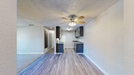 Located at 4407 Oakhollow Dr in Sacramento, California, this two-bedroom, one-bathroom residence offers a practical and comfortable single-floor layout. The combined living and kitchen area forms the heart of the home, where wood-look plank flooring flows through the kitchen and dining space, transitioning to plush carpet in the living room. The living area is bright and airy, highlighted by a ceiling fan with light fixture and a large sliding glass door fitted with vertical blinds that opens to a private balcony overlooking surrounding greenery. The galley-style kitchen is efficiently designed with gray cabinetry on both sides, granite-look countertops, a stainless steel sink, gas range, refrigerator, and dishwasher — all finished with wood-look flooring underfoot. Both bedrooms are carpeted and neutrally toned, offering a calm retreat. The primary bedroom features a sliding closet and a window allowing natural light, while the second bedroom provides similar comfort and direct closet access. A dedicated closet adds additional storage to the layout. The full bathroom is clean and functional, equipped with a tub-shower combination, a granite-look vanity countertop, and wood-look flooring. Textured ceilings are consistent throughout, completing the cohesive aesthetic of this well-appointed Sacramento residence.