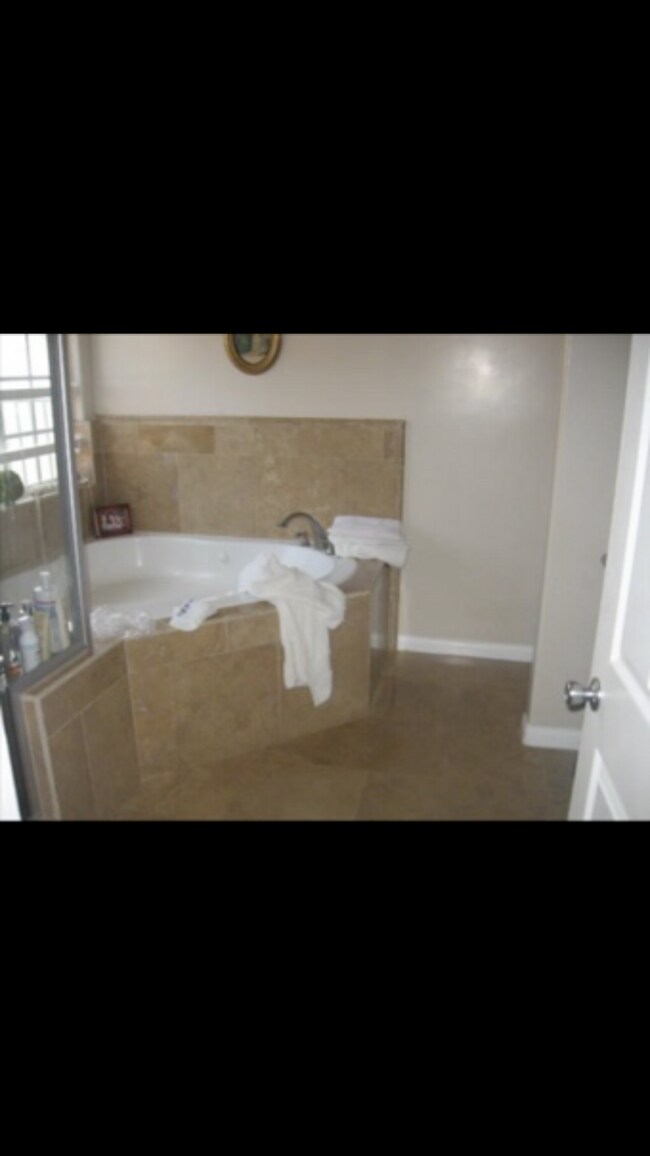 Baño principal con jacuzzi y travertino - 5927 Balcom Ave