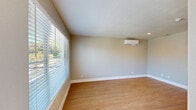 Located at 8288 Lancaster Dr in Rohnert Park, CA, this efficiently designed single-floor residence offers two bedrooms and a living room within a thoughtfully organized layout. Throughout the space, warm wood-look hardwood flooring creates a cohesive, clean aesthetic complemented by neutral gray walls and crisp white baseboards.

The living room serves as the central gathering area, bathed in natural light from a large window that offers views of the surrounding greenery. A ductless mini-split HVAC unit is mounted on the wall, providing efficient and independent climate control. Recessed lighting adds to the bright, open feel of the room.

The primary bedroom is a comfortable, well-proportioned space featuring the same warm hardwood flooring and neutral wall tones. It is equipped with its own wall-mounted mini-split unit for personalized temperature control, as well as a recessed ceiling light. The second bedroom mirrors the clean design with rich, darker wood-look flooring, soft gray walls, and a built-in sliding double closet with paneled doors — offering practical storage. Louvered interior doors add a subtle architectural detail throughout the unit.

The overall ambiance is clean, modern, and move-in ready, with a consistent design language that emphasizes simplicity and functionality across every room.