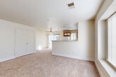 Located at 7929 W Mansfield Pkwy in Lakewood, Colorado, this single-floor, 2-bedroom, 1-bathroom unit offers a practical and efficiently designed layout. The combined kitchen and living area forms the heart of the space. The living room features plush neutral carpet, a ceiling fan, and a large front-facing window that draws in generous natural light. A front entry door opens directly into this area, creating a welcoming entry point.

The kitchen is well-equipped with wood-accented cabinetry featuring white panel fronts, a full suite of white appliances including a refrigerator, electric range, and built-in microwave, as well as a dishwasher. A peninsula with a wood-finished counter and an integrated sink separates the kitchen from the living area, adding both functionality and definition to the open layout. Durable wood-style flooring runs throughout the kitchen.

Both bedrooms are carpeted in the same neutral tones as the living room and include closets with sliding or bifold doors. The primary bedroom offers a comfortable footprint with windows providing natural light. The shared full bathroom features wood-style flooring, a tiled tub-shower combination, a vanity with cabinet storage, and a lighted mirror. A hallway connects the private areas of the unit to the main living spaces.