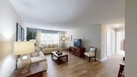 Located in Holly Springs, NC, this 2-bedroom, 2-bathroom single-floor residence at Trellis Pointe offers a well-designed layout with a comfortable, neutral aesthetic throughout. The open-concept living room is a welcoming centerpiece, featuring light wood-style flooring, a textured ceiling, and a large window that draws in natural light, creating a bright and airy atmosphere. The space flows seamlessly into a dedicated dining area, accented by warm-toned walls and clean white trim, providing an ideal setting for everyday meals. The kitchen is efficiently laid out with light wood cabinetry, white appliances including a range and refrigerator, and matching wood-style flooring that ties the common areas together. Both bedrooms are carpeted for added comfort and are equipped with ceiling fans with light fixtures. The generously sized primary bedroom features a warm accent wall and includes a closet, while the second bedroom offers natural light through blinds and curtains. Each bedroom benefits from proximity to a full bathroom, and dedicated closets in both rooms provide practical storage solutions. The overall palette of soft beiges and warm neutrals gives this residence a cohesive, move-in-ready feel throughout.