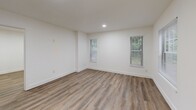 This one-bedroom, one-bathroom unit at 716 N Niles Ave in South Bend, Indiana offers a thoughtfully designed single-floor layout with clean, modern finishes throughout. Wide-plank wood-look vinyl flooring runs continuously through the living area and bedroom, lending a cohesive and contemporary feel to the entire space.

The open living area flows seamlessly into the kitchen, which features white cabinetry, a stainless steel refrigerator, stove, and built-in microwave, along with a sink and countertop workspace. A set of bifold closet doors adjacent to the kitchen provides convenient storage directly in the main living space.

The bedroom is a comfortable, well-proportioned room finished in crisp white walls and the same wood-look flooring. Multiple windows allow natural light to filter in, offering views of surrounding greenery and creating a bright, airy atmosphere.

The bathroom is cleanly appointed with a floating dark-wood vanity topped with a white basin, a wall-mounted mirror, and light-toned flooring that complements the rest of the unit. A dedicated laundry area houses a full-sized GE Profile front-load washer and dryer unit, adding practical in-unit convenience.

Throughout the space, recessed lighting, white trim, and a neutral color palette create a clean and functional environment well-suited for everyday living.