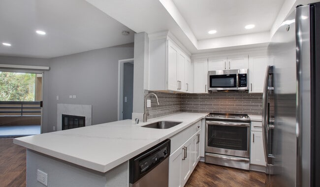 Cocina completa con encimeras de cuarzo y suelo de madera. - 3400 Avenue Of The Arts