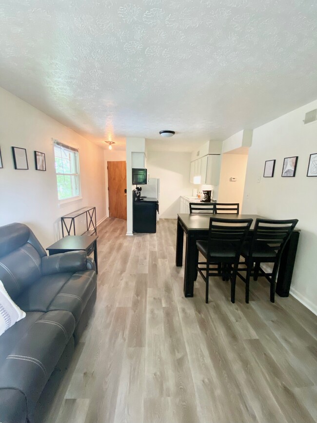 Living room with 2 comfy couches and 4-person dining table - 145 E Wellington Ave