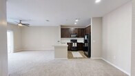 Located at 901 Hidden Valley Drive in Round Rock, Texas, this one-bedroom, one-bathroom unit offers a thoughtfully arranged single-floor layout that maximizes its compact footprint. The open-concept kitchen and living area serve as the heart of the home, where rich dark-espresso cabinetry pairs with a white subway tile backsplash and a generous quartz peninsula countertop complete with an undermount sink. Black appliances, including a refrigerator, range, and microwave, add a cohesive, modern contrast. Recessed lighting illuminates the kitchen, while the adjacent living area benefits from a ceiling fan and plush, neutral-toned carpeting underfoot. A sliding glass door opens directly to a private outdoor patio, filling the living space with natural light and providing a seamless indoor-outdoor connection. The bedroom is a comfortable retreat, featuring soft carpet, a ceiling fan with light fixture, and dual windows dressed with blinds that bring in ample daylight and neighborhood views. A dedicated closet provides convenient storage. The bathroom continues the design language of the home with a dark wood vanity, quartz countertop, framed mirror, and a full soaking tub with large-format tile surround, all set on warm wood-look flooring that ties the space together cohesively.