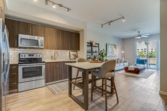 Vista de la cocina y la sala de estar con isla y acceso al balcón privado - South of Atlantic Luxury Apartments