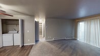 Located at 14901 SE 272nd St in Kent, Washington, this single-floor unit offers a well-organized layout with a variety of functional and comfortable living spaces. The living room serves as the heart of the home, highlighted by a tile-surround fireplace that adds warmth and character. Soft carpeting flows throughout the living and sleeping areas, while durable wood-look flooring runs through the kitchen and bathroom, providing a clean contrast.

The kitchen is thoughtfully appointed with white shaker-style cabinetry, light countertops, and black appliances including a range and refrigerator, all complemented by a ceiling-mounted light fixture and an under-cabinet range hood. A dedicated laundry area with a full-size washer and dryer adds significant convenience.

The bedrooms are well-sized, each featuring carpeted floors, baseboard heating, and natural light from windows with vertical blinds. Built-in shelving is accessible via a separate storage room, offering ample organizational space. The bathroom is clean and efficient, featuring a tub/shower combo, a single-sink vanity with white cabinetry, and wood-look flooring. Neutral gray tones throughout the unit create a calm, cohesive atmosphere well-suited for everyday living.