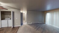 Located at 14901 SE 272nd St in Kent, Washington, this single-floor unit offers a well-organized layout with a variety of functional and comfortable living spaces. The living room serves as the heart of the home, highlighted by a tile-surround fireplace that adds warmth and character. Soft carpeting flows throughout the living and sleeping areas, while durable wood-look flooring runs through the kitchen and bathroom, providing a clean contrast.

The kitchen is thoughtfully appointed with white shaker-style cabinetry, light countertops, and black appliances including a range and refrigerator, all complemented by a ceiling-mounted light fixture and an under-cabinet range hood. A dedicated laundry area with a full-size washer and dryer adds significant convenience.

The bedrooms are well-sized, each featuring carpeted floors, baseboard heating, and natural light from windows with vertical blinds. Built-in shelving is accessible via a separate storage room, offering ample organizational space. The bathroom is clean and efficient, featuring a tub/shower combo, a single-sink vanity with white cabinetry, and wood-look flooring. Neutral gray tones throughout the unit create a calm, cohesive atmosphere well-suited for everyday living.