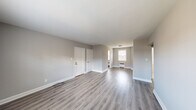 This single-floor unit has been thoughtfully renovated with contemporary finishes and a cohesive, neutral color palette. The open living area is bright and spacious, featuring newly installed gray-toned luxury vinyl plank flooring that runs seamlessly throughout the entire space, complemented by crisp white trim and soft gray walls.

The kitchen stands out with white shaker-style cabinetry extending to the ceiling for ample storage, sleek granite countertops with subtle speckled detailing, a white tile backsplash, and stainless steel appliances — creating a clean, modern cooking environment.

Multiple bedrooms offer comfortable proportions, each benefiting from natural light provided by double-pane windows. Several rooms feature baseboard heating units positioned beneath the windows. One bedroom includes a dedicated closet alongside an additional door, offering practical storage and connectivity within the layout.

The bathroom is finished with white subway-style wall tiles surrounding a full soaking tub and shower combination, with chrome fixtures adding a polished touch.

Throughout the unit, white six-panel interior doors provide a classic contrast against the gray walls, while the consistent flooring and neutral tones create a unified, move-in-ready environment that is both functional and visually appealing.
