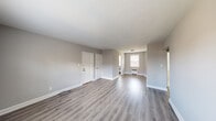 This single-floor unit has been thoughtfully renovated with contemporary finishes and a cohesive, neutral color palette. The open living area is bright and spacious, featuring newly installed gray-toned luxury vinyl plank flooring that runs seamlessly throughout the entire space, complemented by crisp white trim and soft gray walls.

The kitchen stands out with white shaker-style cabinetry extending to the ceiling for ample storage, sleek granite countertops with subtle speckled detailing, a white tile backsplash, and stainless steel appliances — creating a clean, modern cooking environment.

Multiple bedrooms offer comfortable proportions, each benefiting from natural light provided by double-pane windows. Several rooms feature baseboard heating units positioned beneath the windows. One bedroom includes a dedicated closet alongside an additional door, offering practical storage and connectivity within the layout.

The bathroom is finished with white subway-style wall tiles surrounding a full soaking tub and shower combination, with chrome fixtures adding a polished touch.

Throughout the unit, white six-panel interior doors provide a classic contrast against the gray walls, while the consistent flooring and neutral tones create a unified, move-in-ready environment that is both functional and visually appealing.