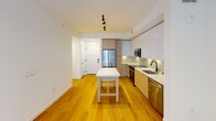 This contemporary 600 square foot apartment in North Miami offers a blend of comfort and style. The single-floor layout comprises one bedroom, measuring 150 square feet, and two bathrooms, providing ample space for both living and privacy.

The heart of the home is a sleek, modern kitchen featuring stainless steel appliances, including a refrigerator and built-in microwave. White cabinetry contrasts beautifully with the warm wooden floors, while under-cabinet lighting illuminates the subway tile backsplash. A central island with seating serves as both a prep area and casual dining space.

The bathrooms exude luxury with marble-effect tiling, glass-enclosed showers, and modern fixtures. One bathroom boasts a backlit mirror and a vibrant yellow vanity, adding a pop of color to the space.

The bedroom, while compact, offers ample natural light through a large window overlooking the property's impressive amenities, including a resort-style pool surrounded by palm trees and lounge areas.

The apartment is part of a larger complex that boasts a tropical aesthetic with its white and beige exterior, multiple balconies, and lush landscaping. Residents can enjoy the outdoor pool area, complete with sunbeds and cabanas, perfect for relaxation and socializing.

This unit combines efficient use of space with high-end finishes, making it an ideal home for those seeking a modern, low-maintenance lifestyle in a vibrant Miami setting.
