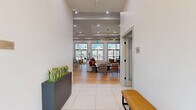 Located at 2220 North Susquehanna Trail in York, PA, this expansive amenity center serves as a premier community hub spanning a generous single-floor footprint. The heart of the space is a bright, open lounge area adorned with a striking multi-arm chandelier, tray ceilings, and large grid-pane windows and French doors that bathe the room in natural light. Thoughtfully curated furnishings — including a generous sectional sofa, organic-shaped coffee tables, and eclectic accent seating — create an inviting, social atmosphere.

The well-appointed kitchen features sage-green shaker cabinetry, white quartz countertops, a subway tile backsplash, stainless steel appliances, and open wood shelving, making it ideal for community gatherings. Adjacent, a professional conference room offers a long wooden table, woven chairs, a wall-mounted display, and abundant natural light through tall windows.

The fitness center is comprehensively equipped with treadmills, ellipticals, a cable machine, spin bikes, free weights, and stability equipment, all set beneath ceiling fans with ample window light. A dedicated strength and cycling area provides additional training versatility. Outside, a resort-style swimming pool is surrounded by lounge chairs and umbrellas, with a spacious sundeck offering views of the multi-story residential buildings.