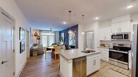 Located at 500 Dalton Way in Little River, SC, this single-story residence offers a thoughtfully designed 2-bedroom, 2-bathroom layout that maximizes every square foot. The open-concept living area seamlessly connects the kitchen, dining room, and living room, creating a bright and functional shared space. Rich light wood-tone flooring flows throughout, complemented by a bold navy accent wall in the dining and living area that adds depth and character.

The kitchen is a standout feature, outfitted with white shaker cabinetry, granite countertops, a central island with undermount sink and pendant lighting, and a full suite of stainless steel appliances including a French door refrigerator, range, microwave, and dishwasher. The living room benefits from natural light through large windows and glass doors leading to an outdoor area.

The primary bedroom features a soothing blue-grey accent wall and hardwood-style flooring, while the second bedroom is bright and airy with large windows. Both bathrooms include granite-topped white vanities, with the full bath offering a tub-shower combination. A dedicated in-unit laundry room with full-size washer and dryer adds everyday convenience. Hallways and a closet complete this efficiently organized home.