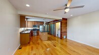 Located in Pittsburgh's South Side neighborhood, this 1-bedroom, 1-bathroom residence offers a thoughtfully designed single-floor layout that maximizes both function and style. The open-concept kitchen and living area serves as the heart of the home, featuring warm hardwood floors, recessed lighting, and a ceiling fan. The kitchen is well-equipped with rich wood cabinetry, dark granite countertops, a center island with pendant lighting, and a full suite of stainless steel appliances including a gas range, microwave, dishwasher, and refrigerator. Natural light flows in through multiple windows, enhancing the inviting atmosphere. A distinctive sliding barn door with frosted glass panels separates the living area from the hallway, adding a modern architectural touch alongside a warm wood accent wall. The bedroom offers a comfortable, carpeted retreat with a ceiling fan, a window with outdoor views, and a built-in closet. The bathroom is finished with tile flooring, a walk-in shower, and a vanity with dark countertops. Additional highlights include multiple closets for ample storage, an in-unit laundry area, and a practical hallway connecting the home's spaces seamlessly.