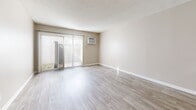 Located in Hacienda Heights, CA, this two-bedroom, two-bathroom single-floor residence offers a well-organized and functional layout. The open-concept living and dining area is finished with light wood-look luxury vinyl plank flooring and neutral warm-beige walls, creating a bright and welcoming atmosphere. A ceiling fan adds comfort, while a wall-mounted AC unit provides climate control. Sliding glass doors with vertical blinds lead to a private patio, allowing natural light to fill the space. The galley-style kitchen features white cabinetry, a gas range, stainless steel refrigerator, dishwasher, and a double sink, all complemented by light wood-look flooring. Both bedrooms are carpeted and feature mirrored sliding closet doors that enhance the sense of space. The primary bedroom includes direct access to one of the two full bathrooms. A hallway lined with additional mirrored closets provides generous storage throughout. The bathrooms are clean and functional, featuring tub/shower combinations with built-in shelving. A dedicated laundry area and utility room add everyday convenience. The textured ceilings and consistent neutral palette throughout contribute to the unit's cohesive, move-in-ready appeal.