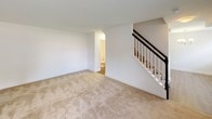 This two-floor residence offers a thoughtfully designed layout that balances functionality and comfort across its multiple levels. The main level features a bright, open living area with neutral-toned carpet, white walls, and a staircase with classic white balusters and a dark handrail leading to the upper floor. A half bath is conveniently accessible from the main living space. The kitchen is a standout feature, showcasing rich dark espresso cabinetry with shaker-style doors, granite countertops with subtle speckled detailing, wood-look flooring, and a full suite of black appliances including a refrigerator, electric range, and over-the-range microwave. The upper level hosts multiple bedrooms, each finished with plush neutral carpet, crisp white walls, and windows with blinds that allow ample natural light and views of surrounding greenery. Closet space is provided in the bedrooms, with bi-fold and panel-style doors. The full bathroom features a dark-framed vanity mirror, a white countertop with an undermount sink set into dark wood cabinetry, tile flooring, and a bathtub with a tiled surround and grab bars for added accessibility. The overall ambiance is clean, bright, and move-in ready.
