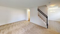 This two-floor residence offers a thoughtfully designed layout that balances functionality and comfort across its multiple levels. The main level features a bright, open living area with neutral-toned carpet, white walls, and a staircase with classic white balusters and a dark handrail leading to the upper floor. A half bath is conveniently accessible from the main living space. The kitchen is a standout feature, showcasing rich dark espresso cabinetry with shaker-style doors, granite countertops with subtle speckled detailing, wood-look flooring, and a full suite of black appliances including a refrigerator, electric range, and over-the-range microwave. The upper level hosts multiple bedrooms, each finished with plush neutral carpet, crisp white walls, and windows with blinds that allow ample natural light and views of surrounding greenery. Closet space is provided in the bedrooms, with bi-fold and panel-style doors. The full bathroom features a dark-framed vanity mirror, a white countertop with an undermount sink set into dark wood cabinetry, tile flooring, and a bathtub with a tiled surround and grab bars for added accessibility. The overall ambiance is clean, bright, and move-in ready.