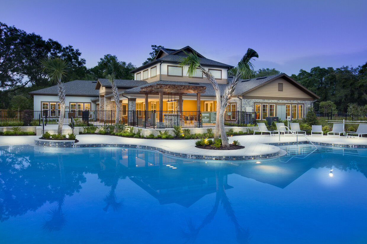 Foto con vista a la piscina con asientos al aire libre, con la casa club al fondo. - Brookview at Citrus Park