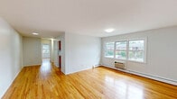 Located at 1703 Lexington Ave in Lakewood, NJ, this one-bedroom, one-bathroom unit offers a well-organized, single-floor layout designed for comfortable everyday living. Warm-toned hardwood flooring runs throughout the main living areas, bedroom, and hallway, lending a cohesive and inviting feel to the entire space.

The living area is bright and open, featuring large windows that frame views of the surrounding neighborhood and allow generous natural light to fill the room. A wall-mounted air conditioning unit and baseboard heating ensure year-round comfort. The space flows naturally through a connecting hallway toward the kitchen and bedroom.

The kitchen is equipped with rich, honey-toned wood cabinetry — both upper and lower — offering ample storage alongside a double-basin stainless steel sink and clean white countertops, creating a practical and tidy workspace.

The bedroom is a well-proportioned retreat, featuring dual closets with sliding doors for generous storage, a window with neighborhood views, and the same warm hardwood flooring found throughout. The bathroom is clean and functional, featuring a full-size tub/shower enclosure.

A connecting hallway ties all rooms together efficiently, completing this thoughtfully laid-out unit in a residential Lakewood neighborhood.