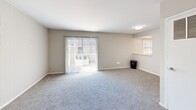 Located at 1326 Lynnhaven Pkwy in Virginia Beach, VA, this 2-bedroom, 1-bathroom unit offers a practical and well-appointed layout across a single floor. The combined kitchen and living room serves as the heart of the unit, with the living area featuring soft carpet flooring, neutral wall tones, and a sliding glass door that opens to a private balcony, allowing natural light to fill the space. A secondary window further brightens the room. The kitchen is outfitted with white cabinetry, quartz-style countertops, a white subway tile backsplash, stainless steel appliances including a range, microwave, and dishwasher, and light wood-style flooring that adds a clean, modern touch. Both bedrooms are carpeted and feature neutral walls with natural light from windows overlooking the outdoors. The primary bedroom offers generous proportions along with a wide sliding closet. The full bathroom includes a shower-tub combination and light wood-style flooring, and is conveniently paired with a stacked in-unit washer and dryer. A hallway connects the rooms, completing this efficiently designed and move-in ready home.