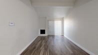 Located at 900 Frances Way in Richardson, TX, this single-floor, one-bedroom, two-bathroom residence offers a well-designed layout that makes efficient use of its space. The open living area immediately impresses with vaulted ceilings and a corner fireplace set against crisp white walls, creating a bright and airy atmosphere. Dark wood-style flooring runs throughout, lending a warm, cohesive aesthetic. A sliding glass door fitted with vertical blinds allows natural light to filter in while providing access to the outdoors.

The galley-style kitchen is a standout feature, showcasing rich dark cabinetry, granite countertops, a classic subway tile backsplash, and black appliances — all combining for a sleek, modern look. A dedicated pantry adds valuable storage. The kitchen flows conveniently into the combined dining and living area, supporting an open-concept feel.

The generously sized bedroom features a ceiling fan, a window with vertical blinds, and its own access to closet space. Four closets throughout the unit ensure abundant storage. The bathrooms are clean and functional, with one featuring a tiled tub-shower surround in a vertical stacked pattern. A hallway and entrance area round out the thoughtfully organized floor plan.