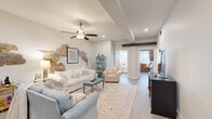 Located on the iconic King Street in Charleston's historic district, this 3-bedroom, 2-bathroom residence masterfully blends historic charm with contemporary finishes across a single, well-organized floor. The living room serves as the heart of the home, featuring an eye-catching exposed brick accent wall that reveals layers of Charleston's storied past alongside crisp white walls, wood-look flooring, recessed lighting, a ceiling fan, and exposed beam details overhead. The kitchen is outfitted with white shaker cabinetry, a subway tile backsplash, stainless steel appliances, and a light quartz peninsula with bar seating — ideal for casual dining. Two hallways guide residents through the layout, connecting the living areas to three comfortable bedrooms, each with ceiling fans and ample closet space. The generously sized primary bedroom offers a tranquil retreat, while the additional bedrooms provide versatility for guests or a home office. Both bathrooms feature white vanities with clean countertops and wood-look tile flooring. Natural light filters throughout the space, enhancing its bright and airy ambiance. This residence offers an authentic Charleston living experience with historic architectural details and modern conveniences in one of the city's most walkable and vibrant neighborhoods.
