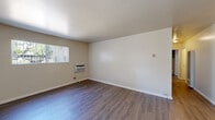 Located at 113 Roxanne Ct in Walnut Creek, CA, this single-floor unit offers a clean, functional layout with a neutral color palette throughout. The living area is spacious and well-lit, featuring durable hardwood-style flooring, a wall-mounted air conditioning unit, and a large sliding glass door fitted with vertical blinds that floods the space with natural light. An entry door provides direct access to this main living area.

The kitchen is efficiently designed with white cabinetry, a countertop workspace, a stainless steel sink, and a full-size refrigerator, providing ample storage and utility for everyday use.

The bedrooms are comfortable and airy, each with hardwood-style flooring and windows that offer views of the surrounding greenery and mature trees. The rooms feature clean white walls, creating a versatile canvas for personalization.

The unit includes two bathrooms. One features a full bathtub and shower combination with a window for natural ventilation. The second is a well-appointed bathroom with a modern vanity topped with a marble-style countertop, an undermount sink, and a mirrored medicine cabinet. Both bathrooms maintain a bright and clean aesthetic. Consistent flooring and neutral tones tie the entire space together cohesively.