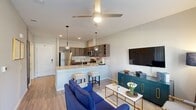 This thoughtfully designed 1-bedroom, 1-bathroom residence offers a cohesive open-concept layout that maximizes both function and comfort. The combined kitchen and living area serves as the heart of the home, featuring light hardwood-style flooring, neutral walls, and a ceiling fan that enhances the airy atmosphere. Large windows dressed with elegant drapes flood the living space with natural light while providing views of the surrounding exterior.

The kitchen is outfitted with rich dark cabinetry, a textured tile backsplash, stainless steel appliances including a refrigerator, range, microwave, and dishwasher, and a generous quartz peninsula countertop with pendant lighting above — ideal for both meal prep and casual dining.

The bedroom offers a comfortable, carpeted retreat with a window that brings in natural light and an adjacent dedicated closet for convenient storage. The bathroom is finished with wood-look flooring, dark cabinetry with a quartz vanity countertop, a large mirror, and a walk-in shower with clean white surrounds. Together, these spaces deliver a modern, cohesive living experience with quality finishes throughout.