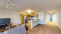 Located on Western Rd in Cedarburg, WI, this well-designed one-bedroom, one-bathroom unit offers a thoughtful single-floor layout with modern finishes throughout. The open-concept living and kitchen area serves as the heart of the home, where light hardwood-style flooring flows seamlessly underfoot. The kitchen is outfitted with warm wood cabinetry, granite countertops, a glass tile backsplash, and a full suite of stainless steel appliances including a French door refrigerator, electric range, over-the-range microwave, dishwasher, and a built-in wine cooler. A peninsula with an extended granite counter provides additional prep space and casual seating. The living room receives natural light through multiple windows fitted with roller shades, and is illuminated by adjustable track lighting overhead. A flexible entry area with a glass-panel door doubles as an office nook, also featuring track lighting. The bedroom offers plush carpeting, a ceiling fan with light fixture, and a horizontal clerestory window. The bathroom is finished with large-format tile flooring, a granite-topped vanity with wood cabinetry, and a glass-enclosed tile shower, creating a clean, spa-like atmosphere.