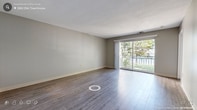 Located at 24 Oyster Bay Rd in Boston, MA, this two-floor residence is designed with functionality and comfort in mind. The layout spans two levels, providing a clear separation between living and private spaces. Throughout the home, wood-style laminate flooring in a warm gray tone lends a cohesive, modern feel to each room.

The main living area is generously proportioned, featuring neutral gray walls and sliding glass doors that open onto a balcony overlooking lush greenery — a standout feature that fills the space with natural light and a sense of openness. A pass-through window connects areas of the main level, adding a practical architectural detail.

The kitchen is equipped with warm oak-toned cabinetry — both upper and lower — paired with light countertops and a stainless steel sink, offering ample storage and workspace. The bedrooms are well-sized, with large windows framing outdoor tree views, and include closets with built-in shelving for organized storage.

The bathrooms feature clean, white tiled tub-and-shower combinations with chrome fixtures and tile flooring, maintaining a consistent and practical aesthetic. Textured ceilings and visible HVAC vents are present throughout, underscoring the home's straightforward, utilitarian design. Overall, the space presents a clean, move-in-ready environment in a residential Boston neighborhood.