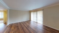Located at 2211 Valleywood Dr SE in Grand Rapids, Michigan, this single-floor residence offers a well-organized layout with a clear separation between living and sleeping areas. The living room serves as a welcoming centerpiece, showcasing rich hardwood flooring, crown molding, and a large sliding glass door fitted with vertical blinds that allows natural light to pour in while offering outdoor views.

The kitchen is a standout space, featuring dark espresso cabinetry paired with granite countertops for a bold, contrasting aesthetic. Black appliances, including a range, over-the-range microwave, and dishwasher, complement the cabinetry, while a stainless steel refrigerator and a stainless undermount sink add modern touches. Hardwood flooring continues throughout the kitchen, and recessed lighting provides a well-lit workspace.

The bedrooms are carpeted for comfort and each benefit from large windows dressed with vertical blinds, offering views of the surrounding neighborhood. Louvered closet doors provide functional storage. The full bathroom includes a granite-topped vanity with an integrated sink, a large mirror, and a full-size tub and shower combination with white tile surround, finished with warm beige walls throughout.