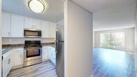 Located at 4302 Palm Ave in La Mesa, California, this two-bedroom, one-bathroom residence offers a clean, modern aesthetic across its single-floor layout. Light wood-look laminate flooring runs throughout the home, creating a cohesive and contemporary feel in every room.

The open living room is generously proportioned, bathed in natural light through a large sliding glass door with vertical blinds that frame views of the lush outdoor greenery. A pass-through connects the living area to the kitchen, enhancing the sense of openness. The kitchen is well-appointed with white shaker-style cabinetry, dark granite-style countertops, and stainless steel appliances including a range, over-the-range microwave, and refrigerator — all set atop matching light plank flooring.

Both bedrooms are comfortably sized with neutral walls, textured ceilings, and windows fitted with vertical blinds that allow for natural light and outdoor views. The primary bedroom offers a notably spacious footprint. The full bathroom features a white vanity with dark granite-style countertops, a large mirror, and a shower-tub combo, maintaining the home's consistent, updated style.

Two hallways connect the rooms efficiently, and the overall neutral color palette throughout creates a bright, move-in-ready atmosphere.