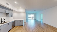 Located at 850 N Azusa Ave in Azusa, CA, this well-designed 3-bedroom, 3-bathroom unit offers a thoughtfully planned single-level layout. The open-concept living and kitchen area serves as the heart of the home, featuring warm luxury vinyl plank flooring that runs seamlessly throughout the entire space. A sliding glass door leads to a private balcony, filling the living area with natural light and providing outdoor views.

The kitchen is a standout feature, showcasing sleek gray shaker-style cabinetry with matte black hardware, a white subway tile backsplash, stainless steel appliances including a range, microwave, and dishwasher, and striking quartz countertops with an extended peninsula — ideal for casual dining or meal prep.

Each of the three bedrooms offers clean white walls and continued vinyl plank flooring. The primary bedroom is a comfortable, well-proportioned retreat. Secondary bedrooms benefit from large windows that invite abundant natural light and outdoor views of the surrounding neighborhood and hillside scenery.

The three bathrooms maintain a consistent, modern aesthetic with gray vanity cabinetry, white quartz countertops, backlit mirrors, and clean white tile surrounds in the tub and shower areas. A dedicated closet adds practical storage to the overall layout, completing this move-in-ready residence.