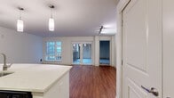 Located at 10527 Main St in the heart of Bellevue, WA, Unit 523 is a thoughtfully designed single-floor residence that blends modern aesthetics with practical functionality. The open-concept living and kitchen area serves as the centerpiece of the unit, anchored by rich hardwood flooring and an abundance of natural light streaming through large windows. French doors lead to a private balcony, offering views of the surrounding Bellevue cityscape.

The kitchen is well-appointed with dark espresso cabinetry, stainless steel appliances including a refrigerator with ice maker, electric range, and over-the-range microwave. A sleek tile backsplash and a generous white quartz island with pendant lighting above complete the space, making it ideal for both everyday cooking and entertaining.

The bedroom features plush carpeting and leads directly into a well-sized en suite bathroom, which boasts a double-sink vanity with quartz countertops, dark wood cabinetry, a large framed mirror, and a tiled shower area. A second bathroom includes a sliding-door shower enclosure, hardwood flooring, and matching dark cabinetry. Additional storage is provided by a walk-in closet with wire shelving. Track and flush-mount lighting is featured throughout, rounding out this polished and functional Bellevue residence.
