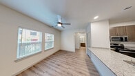 Located at 10420 Hartsook Street in Houston, TX, this single-floor 2-bedroom, 2-bathroom home offers a thoughtfully designed open-concept layout. Light wood-look flooring flows throughout the space, complemented by crisp white walls and recessed lighting that create a clean, modern aesthetic.

The kitchen serves as a central hub, featuring a peninsula with granite countertops and an undermount sink, rich dark-toned cabinetry, stainless steel appliances, and a dedicated pantry. It opens seamlessly into the living area, which benefits from natural light through double windows and a ceiling fan overhead.

Both bedrooms are comfortably sized, with the primary bedroom offering its own closet space and a ceiling fan. Three closets in total provide ample storage throughout the unit. The two bathrooms are finished with granite-topped vanities, wood-toned cabinetry, and light wood flooring. One bathroom includes a full tub-shower combination with white subway tile surround and a curved curtain rod, while the other features a granite vanity with generous counter space.

Additional highlights include a dedicated laundry area, two hallways connecting the home's layout, and a well-organized flow between rooms. The overall design emphasizes practicality and modern style, making this a well-appointed home in Houston's 77034 area.