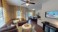 This single-story, 2-bedroom, 2-bathroom residence offers a thoughtfully designed open-concept layout that connects the living, dining, and kitchen areas into one cohesive, functional space. Rich hardwood-style flooring flows throughout the main living areas, complemented by vaulted ceilings fitted with ceiling fans in the living room and bedrooms.

The living area is bright and welcoming, featuring multiple windows dressed with bold chevron-patterned curtains that allow generous natural light. It flows seamlessly into a dedicated dining area, which also benefits from large windows and ample space for a full dining table and chairs.

The galley-style kitchen is well-equipped with dark espresso cabinetry, granite countertops, stainless steel appliances, and abundant storage, with a pass-through opening connecting it to the living space.

Both bedrooms are carpeted and generously sized, each featuring ceiling fans and closet space. The primary bedroom includes an accent wall adding warmth to the room. Each bathroom offers granite-topped vanities with dark cabinetry and a tub-shower combination, maintaining a consistent, cohesive design palette throughout the residence.