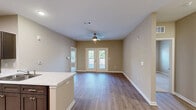 Located at 710 Congaree Rd in Greenville, SC, this single-floor, 2-bedroom, 2-bathroom home offers a well-designed layout with a comfortable and functional living environment. The open-concept kitchen and living area serves as the heart of the home, featuring light hardwood-style flooring, warm neutral-toned walls, and a ceiling fan with lighting. The kitchen is well-appointed with dark espresso cabinetry, stainless steel appliances including a range, microwave, refrigerator, and dishwasher, complemented by sleek marble-style countertops and a peninsula with a built-in sink. French doors in the living area flood the space with natural light and provide access to an outdoor area. The primary bedroom is generously sized, featuring plush carpeting, a ceiling fan, dual windows for natural light, and direct access to a private en-suite bathroom along with a dedicated walk-in closet with built-in wire shelving. The second bedroom is equally well-proportioned with similar carpet and ceiling fan finishes. Both bathrooms are clean and functional, with one featuring a full soaking tub and shower combination. A hallway connects the bedrooms and provides additional storage access, completing this practical and inviting single-story home.