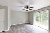 Located at 2911 Chimney Rock Dr in Nacogdoches, Texas, this two-story home offers three bedrooms, three bathrooms, and a practical layout spread across two well-proportioned floors. The main level features a bright living area with light wood-look flooring and a ceiling fan, alongside sliding doors that invite natural light and outdoor views. The kitchen is outfitted with ample white cabinetry accented by gold hardware, light granite-style countertops, a double sink, dishwasher, and a full suite of appliances including a black refrigerator and range. Light wood-look flooring continues throughout the main level, creating a cohesive and easy-to-maintain finish. The upper floor houses the bedrooms, each carpeted and equipped with ceiling fan and light fixtures. The spacious primary bedroom includes a dedicated closet with built-in shelving. Additional bedrooms feature windows overlooking the surrounding greenery, filling each room with natural light. The home includes four closets total, providing generous storage. The three bathrooms feature tub-shower combinations with white subway tile surrounds, with one bath showcasing dark wood-look flooring and brushed nickel accents. A staircase connects the two levels, completing this functional and comfortable Nacogdoches home.