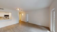 This thoughtfully laid-out 1-bedroom, 1.5-bathroom residence delivers a bright, modern living experience across a single floor. Light wood-style flooring runs throughout the space, tying together a cohesive and contemporary aesthetic. The open living area is generously proportioned, featuring a track lighting fixture and a glass-panel door that opens directly onto a private balcony, filling the room with natural light and offering an outdoor retreat. The kitchen is positioned adjacent to the living area and is equipped with white shaker-style cabinetry, light quartz countertops, a classic subway tile backsplash, and stainless steel appliances including a refrigerator, dishwasher, and range. The bedroom provides a comfortable, quiet retreat with dual windows fitted with blinds, a ceiling fan, and ample floor space. The full bathroom features a tub-shower combination with white tile surround, a vanity with white cabinetry, and wood-style flooring. The half bathroom is equally refined, showcasing a wide-format vanity with a quartz countertop, undermount sink, brushed gold faucet, white cabinetry, and a large mirror. Clean white walls and consistent finishes throughout lend the space a fresh, move-in ready feel.