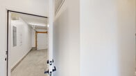 Located at 2130 S 18th Ave in Bozeman, Montana, this contemporary multi-level residence offers a thoughtfully designed layout spread across three floors. The ground level features a spacious attached garage with a polished concrete floor, an automatic garage door opener, and recessed linear lighting — providing generous storage and vehicle access. An interior door connects the garage directly to the living space above.

The main living floor is bright and open, anchored by a modern kitchen equipped with stainless steel appliances, a built-in microwave, a flat-top range, and a refrigerator. Cabinetry features a clean two-tone design with white uppers and warm wood-tone lowers, complemented by white subway tile backsplash and light quartz countertops. Light luxury vinyl plank flooring runs throughout, lending warmth and continuity across the main level.

The upper floor houses the bedrooms, each finished with the same light LVP flooring and crisp white walls. Large windows invite natural light and offer views of the surrounding neighborhood. A well-appointed bathroom features a wood-tone vanity with a white quartz countertop, a large mirror, and a fully tiled walk-in shower with glass enclosure. Recessed lighting is found throughout the upper level. The clean, minimalist aesthetic and modern black hardware accents give the entire home a cohesive, contemporary character.