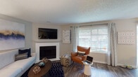 Located at 601 SE 121st Ave in Vancouver, Washington, this single-floor residence offers a well-designed layout with comfortable living spaces throughout. The living room serves as a central gathering area, anchored by a white-mantled fireplace and a wall-mounted television. Large windows with blinds and patterned drapes allow natural light to fill the room, while wood-look flooring adds warmth and continuity.

The kitchen is efficiently designed with white cabinetry, grey countertops, and a full suite of stainless steel appliances including a range, dishwasher, and refrigerator. Wood-look flooring continues here, lending a cohesive feel to the space.

The unit features multiple bedrooms, each finished with plush carpeting and windows that provide natural light. The primary bedroom includes a closet with sliding doors, while a secondary bedroom offers flexible use. A full bathroom includes a vanity with grey countertops, white cabinetry, and a shower/tub combination.

The hallway connects the living areas to the bedrooms and provides access to in-unit laundry. Textured ceilings and neutral wall tones are consistent throughout, contributing to a clean, understated aesthetic across the entire residence.
