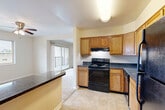 Located at 38 N Summit Dr in Gaithersburg, MD, this single-floor, two-bedroom, one-bathroom home offers a well-organized layout designed for comfortable everyday living. The living room is generously proportioned, featuring warm neutral-toned walls, plush wall-to-wall carpeting, and crown molding that adds a subtle architectural detail. A sliding glass door opens to a private balcony, allowing natural light to flow into the adjacent living and dining areas.

The kitchen is efficiently designed with warm oak cabinetry, dark granite-style countertops, and a full suite of black appliances including a range, dishwasher, and refrigerator. A peninsula counter provides additional workspace and creates a natural transition into the living area. Tile flooring anchors the kitchen and extends practicality throughout.

The spacious primary bedroom comfortably accommodates large furniture and features its own dedicated closet. The second bedroom benefits from a wide window with outdoor views and plush carpeting. Notably, the home offers abundant closet storage throughout, including multiple reach-in closets and an additional walk-in storage space. The bathroom is finished with large-format stone-look tile surrounding a full soaking tub, complemented by a wood-toned vanity and tile flooring.