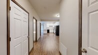 Located in South Bloomfield, Ohio, this well-appointed single-floor home offers three bedrooms, three bathrooms, and a thoughtfully designed layout that balances comfort and functionality. The open-concept kitchen is a standout feature, showcasing crisp white cabinetry extending to the ceiling, granite-look countertops, a peninsula with bar seating, recessed lighting, and black appliances including a range, microwave, and refrigerator. Wood-look vinyl flooring runs throughout the main living areas, adding warmth and durability. The living area is bright and welcoming, highlighted by French doors that open to a private balcony with outdoor views. Each of the three bedrooms offers plush carpeting and natural light from large windows. The generously sized primary bedroom features a dedicated walk-in closet outfitted with wire shelving on multiple walls for ample storage. The three bathrooms are finished with wood-look flooring, clean white fixtures, and a tub-shower combination. Dark wood door and window trim throughout the home adds a refined contrast to the neutral color palette. The overall ambiance is clean, modern, and move-in ready, making this an inviting and practical living space.