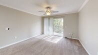 Located at 1545 Kennedy Blvd in Lakeland, Florida, this single-floor, three-bedroom, two-bathroom home offers a well-organized layout with a welcoming entrance and comfortable living spaces throughout. The kitchen is a standout feature, outfitted with sleek gray shaker cabinets, light stone countertops, stainless steel appliances including a range and refrigerator, a deep undermount sink, and light wood-style flooring — all illuminated by recessed lighting. A galley-style section provides additional prep and storage space. The open kitchen flows into the combined living and dining area, which is carpeted and bathed in natural light from a sliding glass door that opens to a balcony overlooking lush greenery. Each of the three bedrooms features plush carpeting, ceiling fans, and neutral-toned walls. The primary bedroom includes a walk-in closet, while additional bedrooms are served by their own closets. Both bathrooms are finished with wood-style flooring, tub-shower combinations, and gray vanity cabinetry with light countertops, maintaining a consistent, clean aesthetic. Three closets throughout the home provide ample storage. The overall ambiance is bright, neutral, and move-in ready.