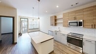 This contemporary 660 square foot apartment in Herndon, VA, offers a thoughtfully designed living space on a single floor. The heart of the home is the open-concept kitchen and living area, showcasing a perfect blend of style and functionality. The kitchen boasts sleek, two-tone cabinetry with warm wood upper cabinets and light lower units, complemented by stainless steel appliances and a subway tile backsplash. A generous island with a quartz countertop serves as both a prep area and casual dining space.

The 150 square foot primary bedroom provides ample space for rest and relaxation, featuring wood-look flooring and recessed lighting. Large windows throughout the apartment allow for abundant natural light, creating a bright and airy atmosphere. The bathroom is designed with modern fixtures, including a floating vanity and a spacious shower area.

Throughout the apartment, the cohesive use of materials, such as the continuous wood-look flooring and white walls, creates a sense of flow and spaciousness. The property at 13280 Woodland Park Rd combines urban convenience with contemporary design, making it an ideal residence for those seeking a stylish and efficient living space in Herndon.
