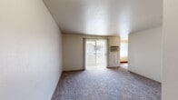 Located at 1960 S Chelton Rd in Colorado Springs, CO, this single-floor unit offers three bedrooms and one bathroom within a practical and efficiently laid-out floor plan. The living area features plush carpeting and a textured ceiling, with a sliding glass door dressed in vertical blinds that allows natural light to fill the space and provides access to an outdoor area. A wall-mounted AC unit ensures year-round comfort. The kitchen is well-equipped with light wood cabinetry, laminate countertops, a stainless steel sink, and wood-look flooring, with white appliances including a refrigerator, stove, and dishwasher. Adjacent to the kitchen is a bright dining area with matching wood-look flooring and a large window. The generously sized primary bedroom features carpeting, a sliding closet, and convenient access to the shared bathroom. Additional bedrooms are carpeted and offer ample wall space and natural light, with one bedroom showcasing a large window with mountain views. The bathroom includes a vanity with storage and wood-look flooring. Throughout the unit, neutral tones and clean finishes create a consistent, move-in-ready ambiance.