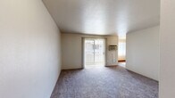 Located at 1960 S Chelton Rd in Colorado Springs, CO, this single-floor unit offers three bedrooms and one bathroom within a practical and efficiently laid-out floor plan. The living area features plush carpeting and a textured ceiling, with a sliding glass door dressed in vertical blinds that allows natural light to fill the space and provides access to an outdoor area. A wall-mounted AC unit ensures year-round comfort. The kitchen is well-equipped with light wood cabinetry, laminate countertops, a stainless steel sink, and wood-look flooring, with white appliances including a refrigerator, stove, and dishwasher. Adjacent to the kitchen is a bright dining area with matching wood-look flooring and a large window. The generously sized primary bedroom features carpeting, a sliding closet, and convenient access to the shared bathroom. Additional bedrooms are carpeted and offer ample wall space and natural light, with one bedroom showcasing a large window with mountain views. The bathroom includes a vanity with storage and wood-look flooring. Throughout the unit, neutral tones and clean finishes create a consistent, move-in-ready ambiance.